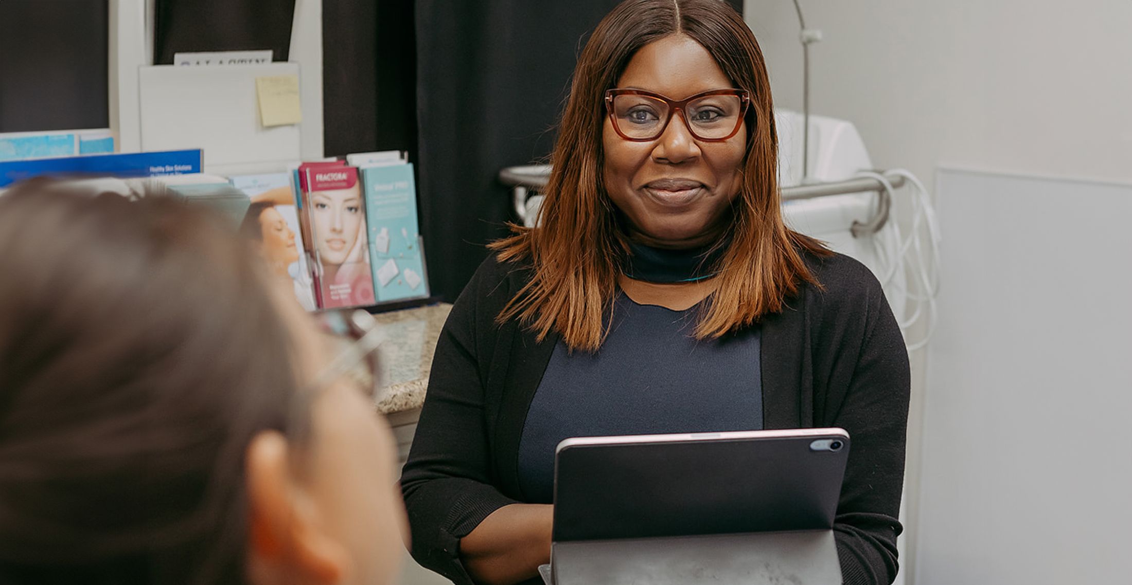 Woman in an office holding a tablet.