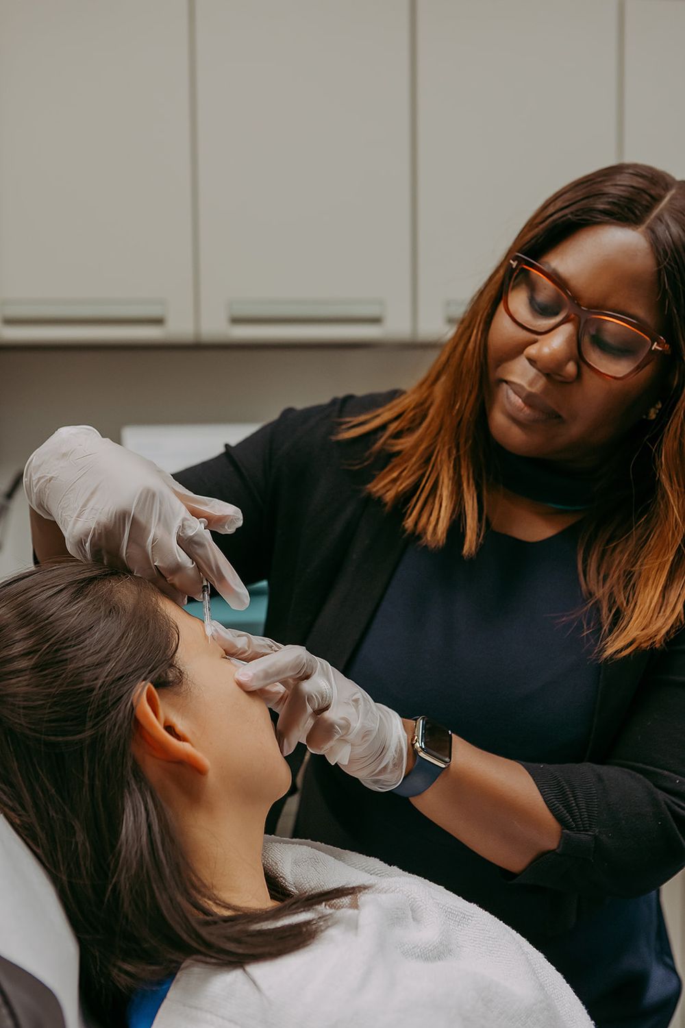 Practitioner administering treatment to patient in clinic