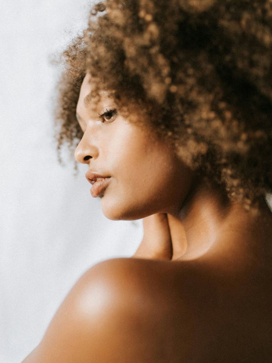 Smiling person in cozy sweater, joyful expression.